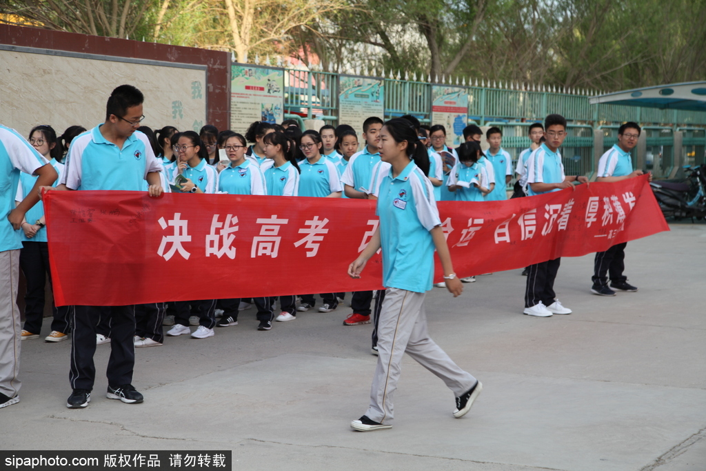 新疆哈密：高考第一日 低年級(jí)學(xué)生家長(zhǎng)送考沿路壯行