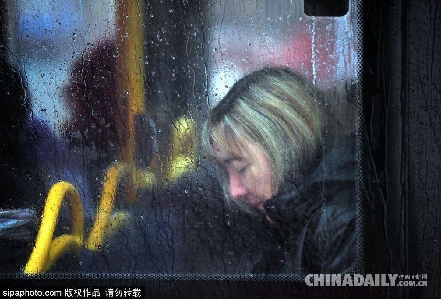 英國(guó)倫敦雨天狂風(fēng)大作 民眾出行雨傘被吹翻