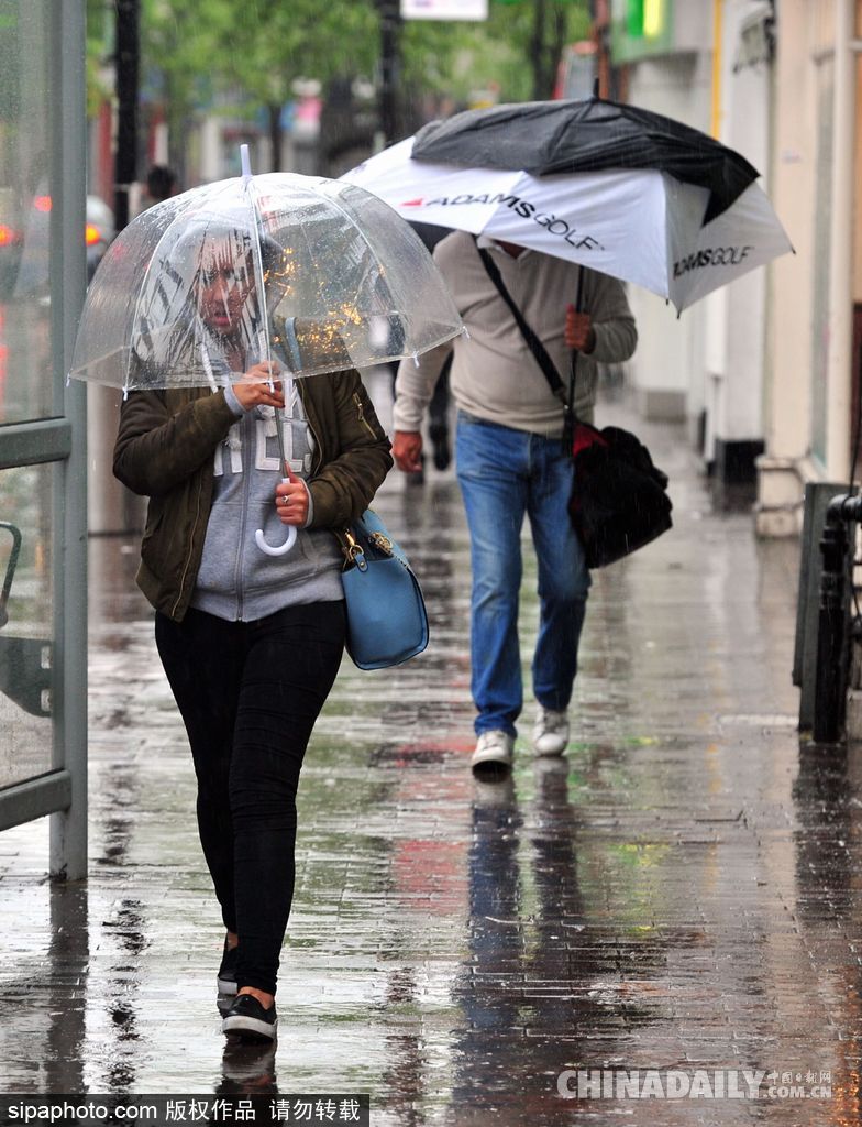 英國倫敦雨天狂風(fēng)大作 民眾出行雨傘被吹翻