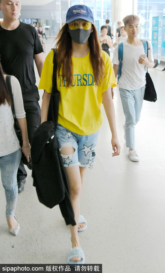 關曉彤黃T短褲踩拖鞋現身上海機場 獲眾人護駕見鏡頭比V賣萌