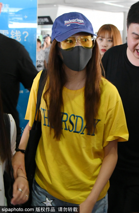 關曉彤黃T短褲踩拖鞋現身上海機場 獲眾人護駕見鏡頭比V賣萌